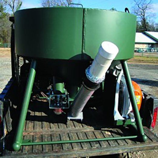 A green bulk hopper with a remote control system, mounted on a trailer, with components including a road feeder, gravity tube, and blower system.
