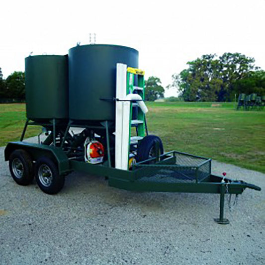 A green and white bulk bird feeder trailer with a ladder and extra tubing, parked on a gravel surface.