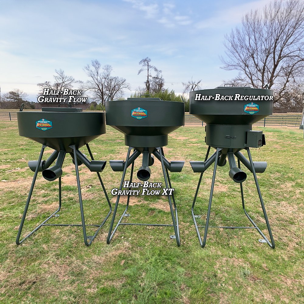 Three wildlife feeders of different models placed outdoors on stands, labeled as Half-Back Gravity Flow, Half-Back Gravity Flow XT, and Half-Back Regulator.