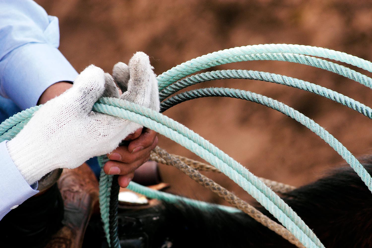 Close-up of hands holding a rope with a blurred background