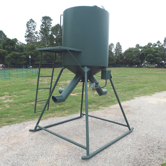 A green dual hopper feeder designed for protein and corn distribution, mounted on a metal frame.