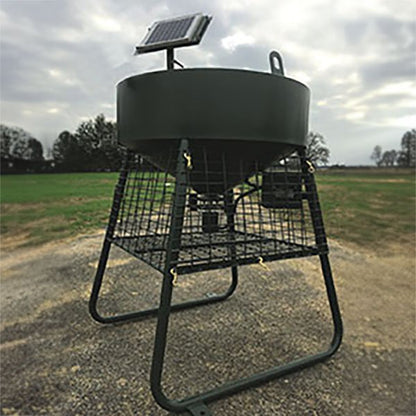 A green corn feeder with a solar panel on top, mounted on a metal frame, located outdoors.